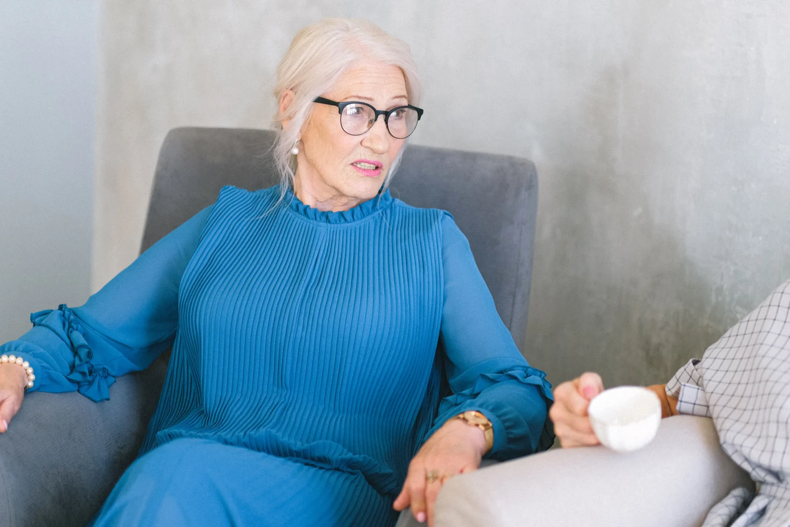Older woman having a relaxed conversation with a companion at home